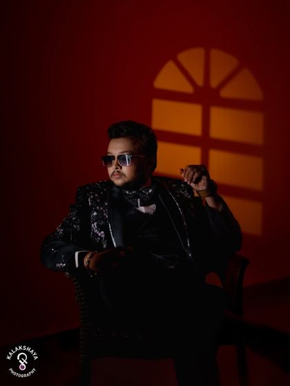 A stylish, low-key portrait of the groom in a sequined tuxedo, using creative lighting for a dramatic effect.