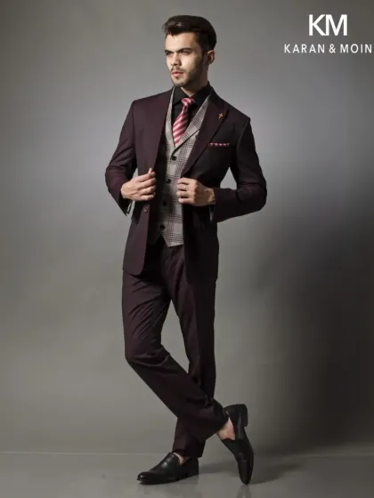 Another angle of the burgundy three-piece suit, showing how the garment moves with the wearer. The clean lines are maintained even in a dynamic pose.