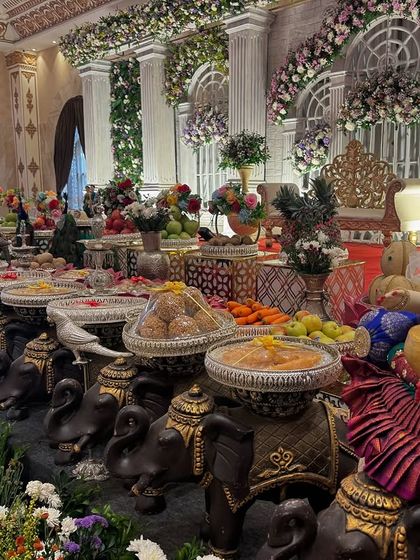 A close-up of the offering table in front of the classical pillar stage, with a focus on the dolls and props.