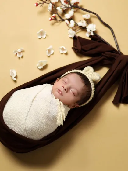 Another variation of the hanging sling pose, showing the baby from a different perspective. Safety is always our number one priority in creating these images.