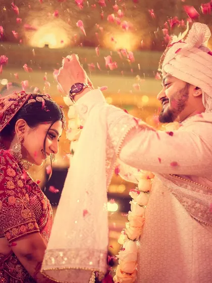 The joy of a varmala ceremony is infectious. We capture the energy with dynamic shots, like this one where the couple is showered in petals, freezing a perfect, happy memory in time.