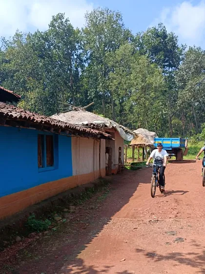 Pedaling past a brightly colored home in a Gond tribal village. The routes are carefully designed to immerse you in the local culture and stunning scenery of the Kanha region.