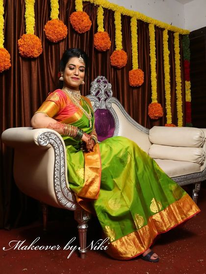 A full-length view of Nirosha's stunning engagement look, showing how the makeup, hair, and her beautiful green silk saree create a complete and cohesive style.