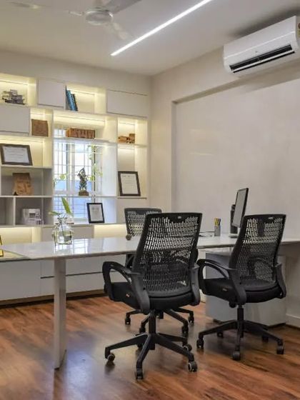 One of the director's cabins in the SAS office. A glass partition maintains a connection to the main studio, while a backlit shelving unit provides ample space for displaying books, models, and awards.