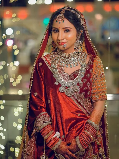A half-body portrait capturing the bride's gentle smile against a backdrop of festive lights.