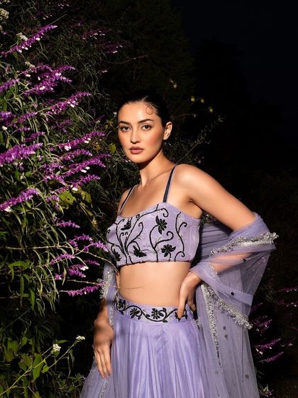 A magical night-time fashion shoot for Baavli. The flash illuminates the model and the lavender flowers, creating a dramatic contrast with the dark background.