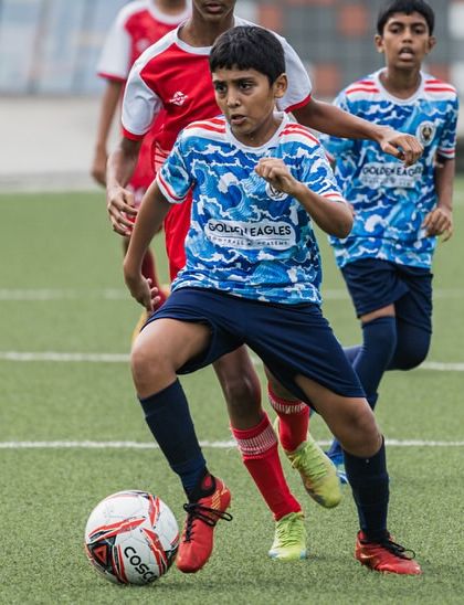 A player shields the ball from an opponent. Our training includes developing the physical strength and game intelligence to maintain possession.