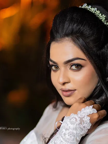 A close-up of a model's face, showcasing a beautiful Christian wedding makeup look with defined eyes and a soft lip.
