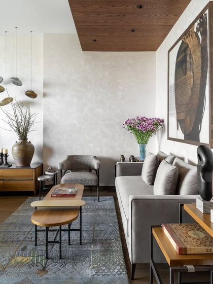 The sitting area within the master bedroom suite, featuring a comfortable sofa and armchair from our Koko collection. A textured Jaipur Rug underfoot and a dramatic Gopi Gajwani painting on the wall create a sophisticated space for relaxation.