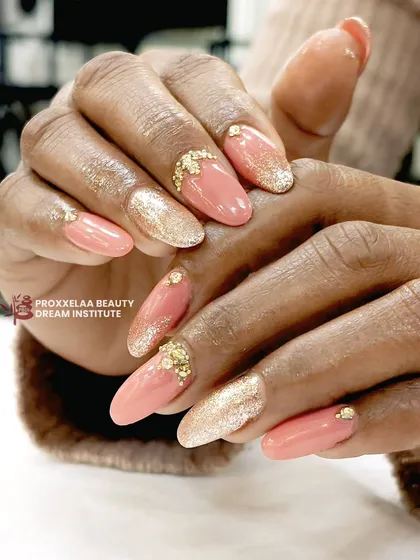 A soft and feminine glam look. This set combines a peachy-pink base with full-coverage gold glitter accent nails and delicate gold leaf detailing.