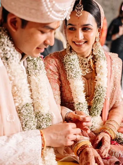 A close up of the wedding rituals, showcasing the intricate details of the bride's attire and the gentle connection between the couple.