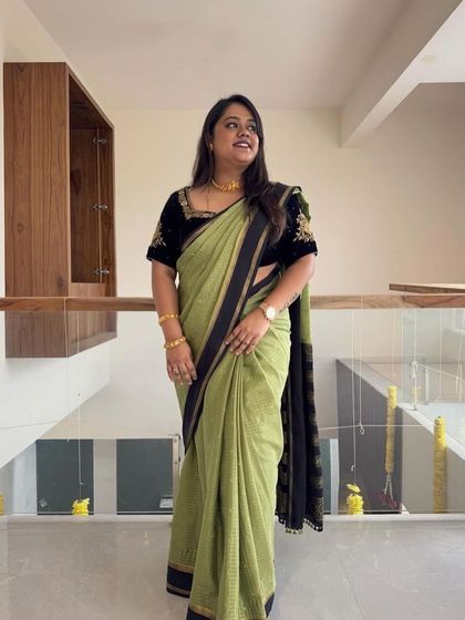 A client looking beautiful in a green checks pure Mysore crepe saree with a custom black embroidered blouse.