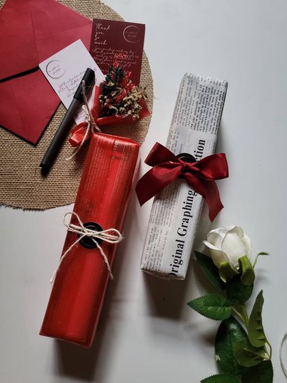 Two different wrapping styles for the scroll letter boxes. One is classic red, and the other is vintage newspaper print, both finished with a beautiful ribbon.