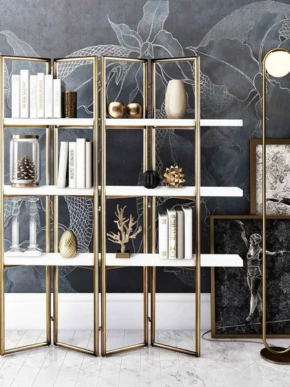 Our statement shelving unit, shown here styled in a chic living space. The folding design allows for versatility, while the combination of the gold-finished frame and white shelves exudes modern luxury.
