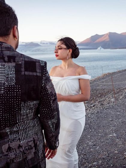 Another perspective of the ethereal white gown look. The bride's soft updo highlights the gown's neckline, while the groom's patterned blazer adds a touch of modern edge.