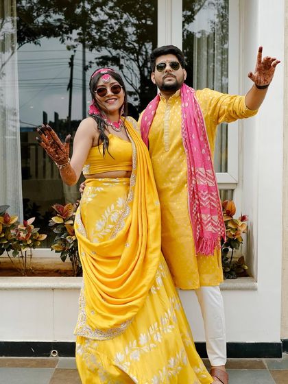 A happy couple shot from the Haldi function. The bride's makeup is bright and cheerful, perfectly matching the vibe of the event.
