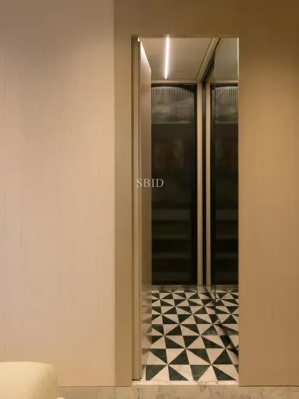 A view into the master bathroom through a hidden door, revealing the striking geometric floor and the spacious walk-in wardrobe beyond.