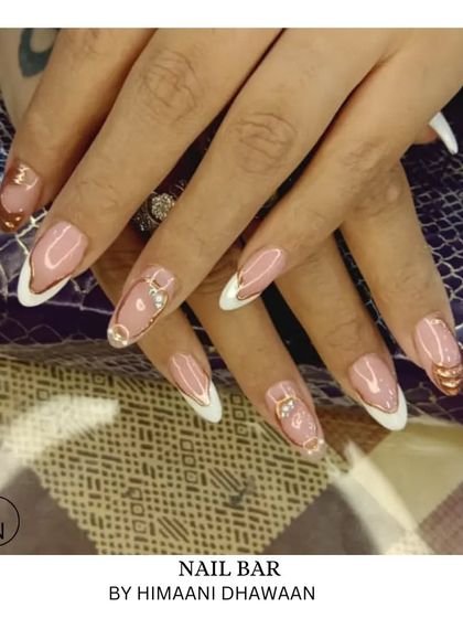 A sophisticated design combining French tips with gold accents and 3D ring embellishments for a very chic and modern look.