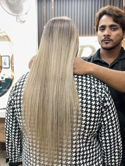 Our stylist proudly presenting the final result of this stunningly long, sleek, ash-blonde color and style.