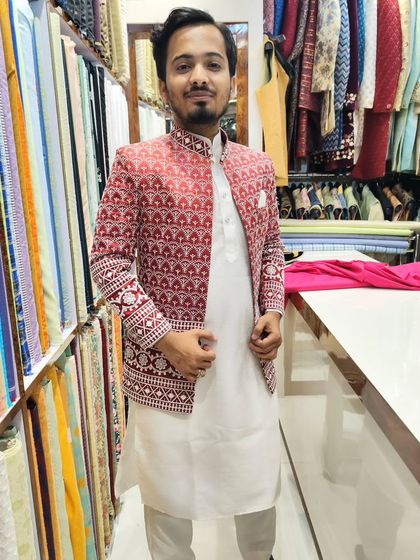 A client trying on the red and white embroidered open jacket in my studio. The fit is tailored to be comfortable yet sharp.