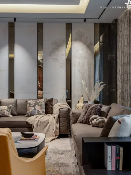 A close-up of the living area at our Rigeria project, a masterclass in quiet luxury. The design whispers refinement through a curated selection of textures, from the plush throw and cushions on the sofa to the vertically paneled wall with integrated mirrors.