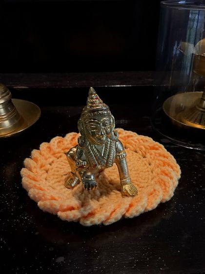 A crochet 'asan' in a lovely peach color for a 'Bal Krishna' idol.