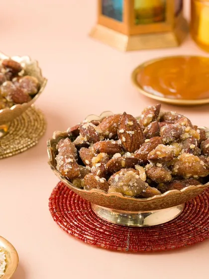 Caramelized almonds presented in ornate brass bowls. We use traditional props to enhance the festive and premium feel of the products.