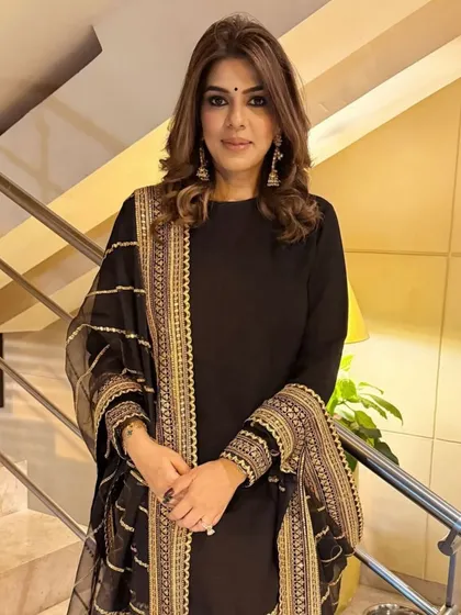 A full view of the soft curls, which add a lovely softness to this elegant black and gold ensemble.