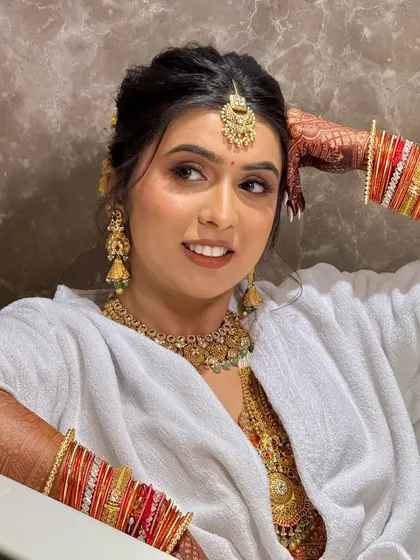 A candid moment in a bathrobe after the makeup is done. This shows the bride's readiness and the long-lasting quality of the makeup.