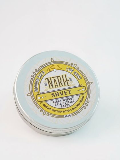 A clean product shot of a tin of hair styling paste. The white background and simple lighting are ideal for creating a consistent look across a brand's website.