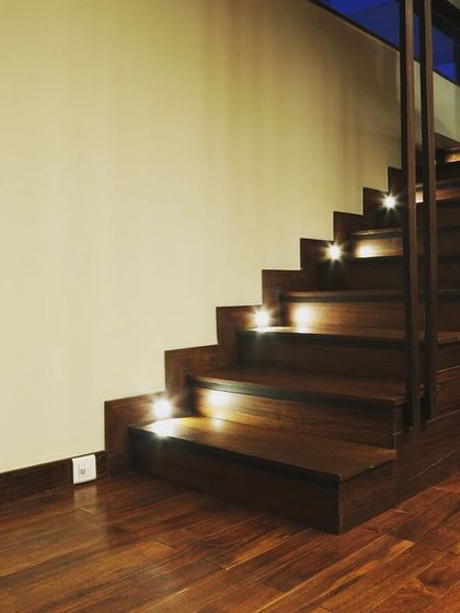 The illuminated staircase at night creates a dramatic and welcoming effect.