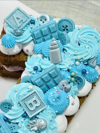 A detailed view of the blue-themed first birthday monogram cake.