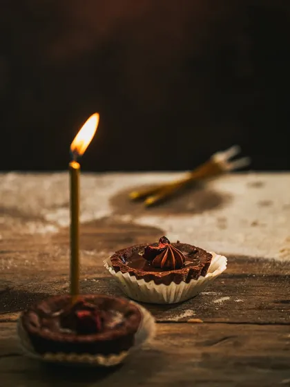 The final shot in the tart series, with warm, focused light on the candle, creating a classic, timeless birthday feel.