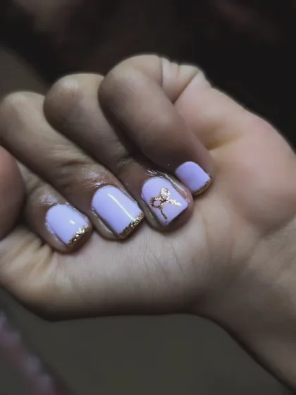 A pretty purple set with a twist. I used a light lavender gel polish and added gold glitter along the cuticles and on the tips for a delicate, framed look. A 3D bow charm completes the design.
