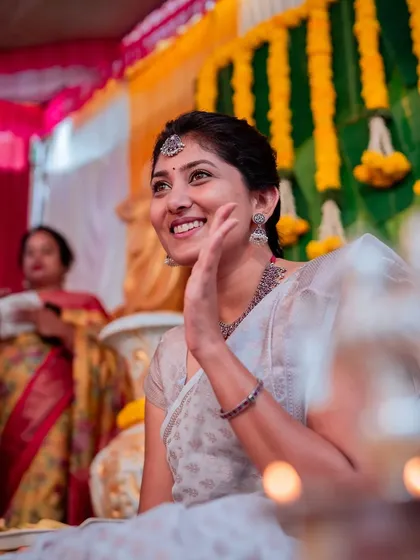 A candid shot of the bride waving happily during her Haldi. We focus on capturing natural expressions and real emotions.