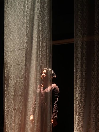 A daughter yearns for the outside world in "The House of Bernarda Alba." The set and lighting design create a feeling of confinement, with light representing a hope for freedom.