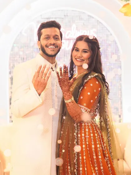 The happy couple showing off their rings. Her makeup is fresh and natural, perfect for a daytime engagement event.