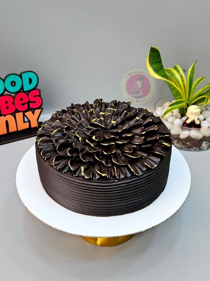 One of our bestseller designs. This rich chocolate truffle cake is decorated with a beautiful petal effect, created using a simple piping technique.