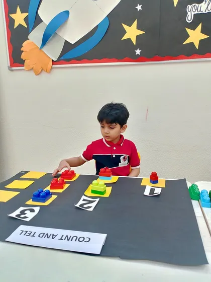 Math becomes a fun puzzle to solve with our "Count and Tell" block activity. Here, a young student is focused on matching the number of colorful blocks to the corresponding numeral, building a strong foundation for number recognition and counting skills.