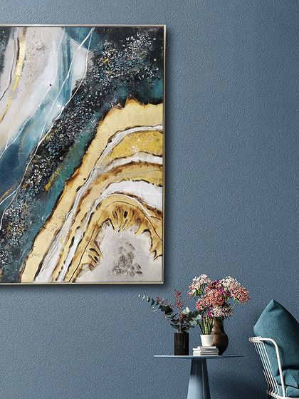 This abstract resin art painting evokes a sense of a flowing river or a beautiful mineral cross-section. The deep blues and earthy yellows are separated by lines of sparkling crystals and gold.