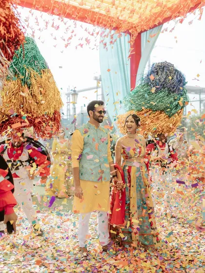 A joyful shot of the couple completely immersed in the confetti and the celebratory atmosphere.