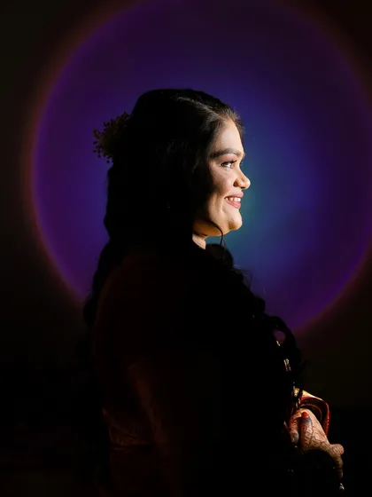 A creative silhouette portrait using a sunset lamp to create a colorful halo effect. This technique produces a unique and artistic image that stands out from traditional portraits.