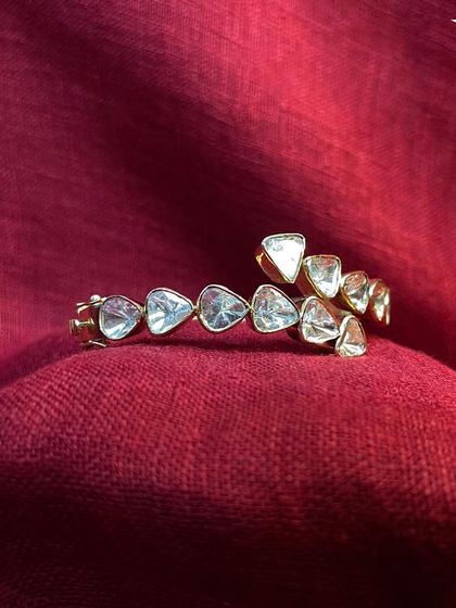 This unique polki bracelet features triangular uncut diamonds, creating a modern and edgy design. It's a statement piece that will make you stand out at any wedding or festive occasion.