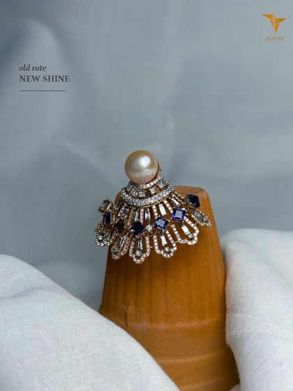 This dramatic ring features a large pearl surrounded by a fan of diamonds and sapphires. It's a perfect statement piece for wedding season festivities.