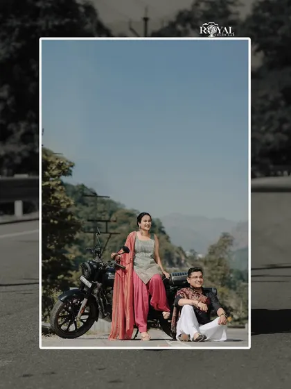 A stylish shot of a couple in ethnic wear posing with a motorcycle, blending tradition with a modern, adventurous spirit.