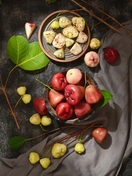 I love playing with color and composition in food photography. This image contrasts the different colors of water apples against a dark background, with some sliced to show their texture with masala.