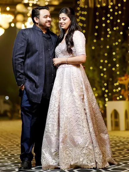 A classic couple portrait from an engagement party, with a beautiful bokeh background of festive lights.