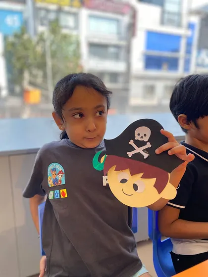 This student looks off-camera while holding his pirate mask, perhaps thinking about the character he's about to play.