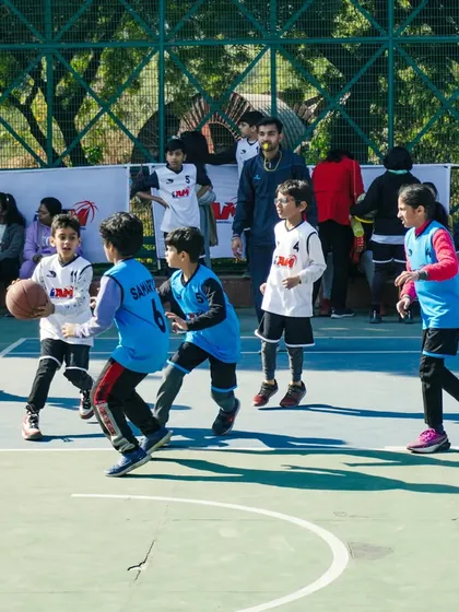A young player with the ball, being defended closely. This drill simulates game pressure and teaches how to protect the ball.
