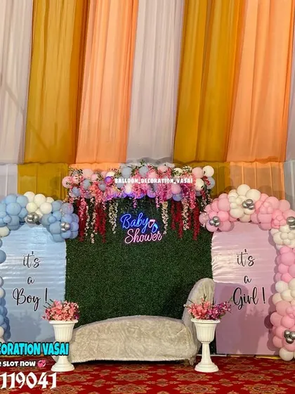 This gender reveal setup uses two distinct color-coded sections for "It's a Boy" and "It's a Girl". The central green turf wall with a neon sign brings both sides together beautifully.